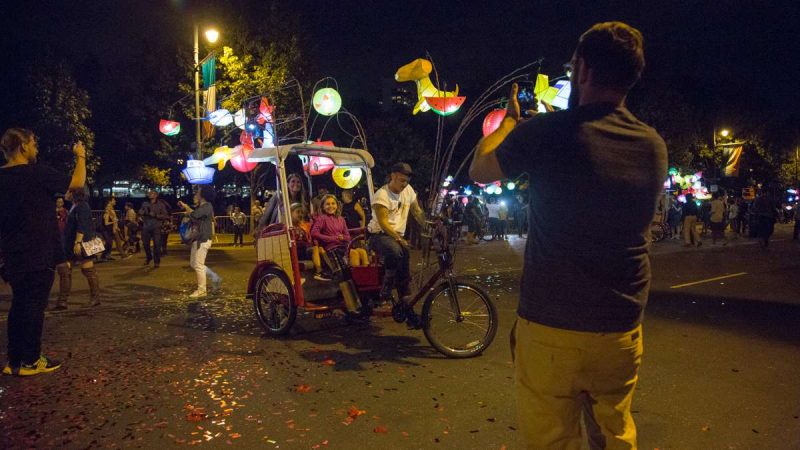 A family takes a portrait on a pedicab at the opening of ''Fireflies'' on the Ben Franklin Parkway. (Emily Cohen for NewsWorks)