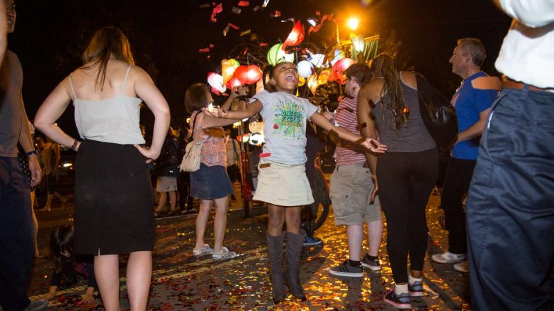 Nia Adams, 6, plays with the confetti after the debut of ''Cai Guo-Qiang: Fireflies'' on the Ben Franklin Parkway in Philadelphia September 14th 2017. (Emily Cohen for NewsWorks)