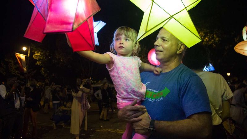 Bridget Corrigan, 3, is held up by her father, Jim, for a closer look at the lanterns after their debut in ''Cai Guo-Qiang: Fireflies'' on the Ben Franklin Parkway in Philadelphia September 14th 2017. (Emily Cohen for NewsWorks)