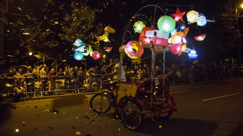 Confetti flies as a pedicab performs in the debut of ''Cai Guo-Qiang: Fireflies'' on the Ben Franklin Parkway. (Emily Cohen for NewsWorks)