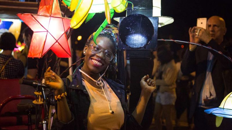 Eve Kabah poses for a photo with the lanterns after the debut of ''Cai Guo-Qiang: Fireflies'' on the Ben Franklin Parkway in Philadelphia. (Emily Cohen for NewsWorks)