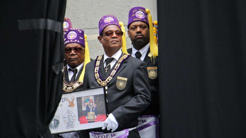 Members of the Octavius V. Catto African-American Elks Lodge await the unveiling of the monument wearing purple hats with yellow tassles