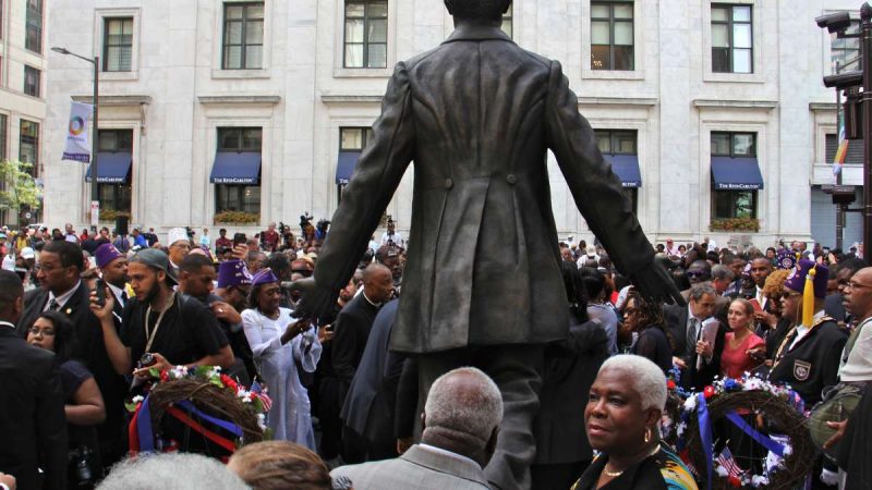The statue steps forward with hands extended, as if waiting to be grasped, from the back , his coat tails are carved