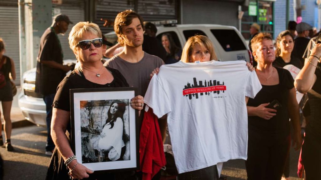march_in_black_20170901_1361604135 Donna Morgan, (left), stands with a picture of her daughter Brittany who died of a heroin overdose in May 2017 along with her son Nathan and friend Robin D'Angleo whose son is in recovery for heroin addiction. (Brad Larrison for NewsWorks)