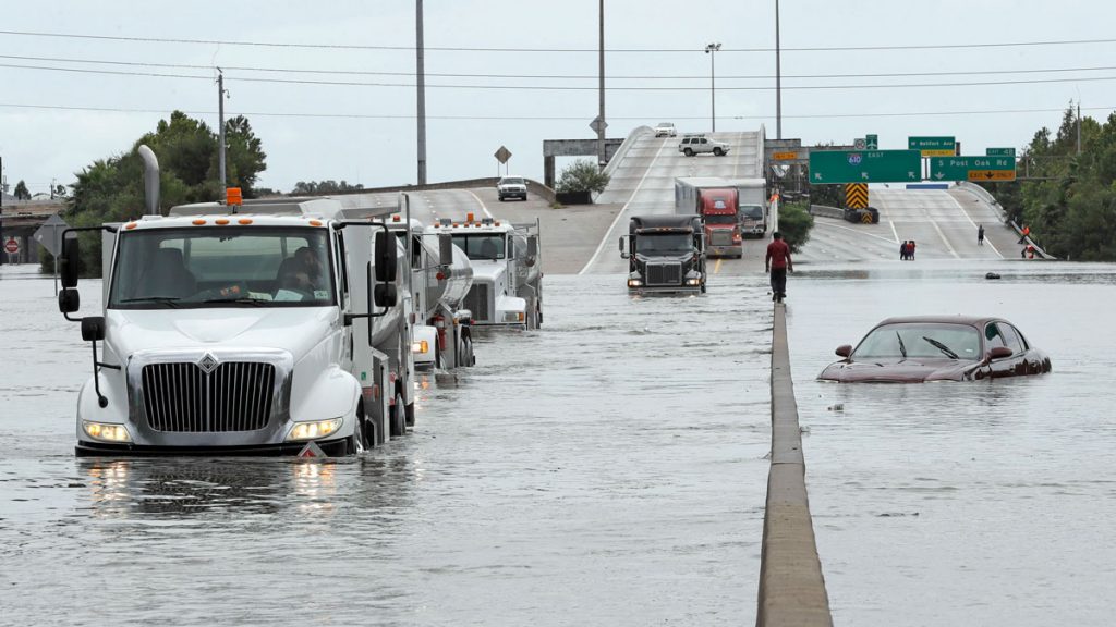 texas-flood-highway-1200 A man walks down the median as trucks navigate floodwaters from Tropical Storm Harvey along Interstate 610 Sunday, Aug. 27, 2017, in Houston, Texas. (AP Photo/David J. Phillip)