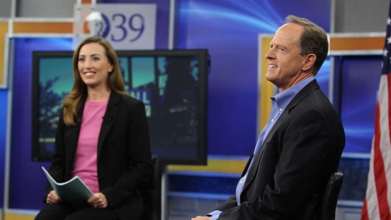 U.S. Sen Pat Toomey takes the stage with WLVT-PBS39 host Laura McHugh for a televised town hall meeting in Bethlehem. (Emma Lee/WHYY)
