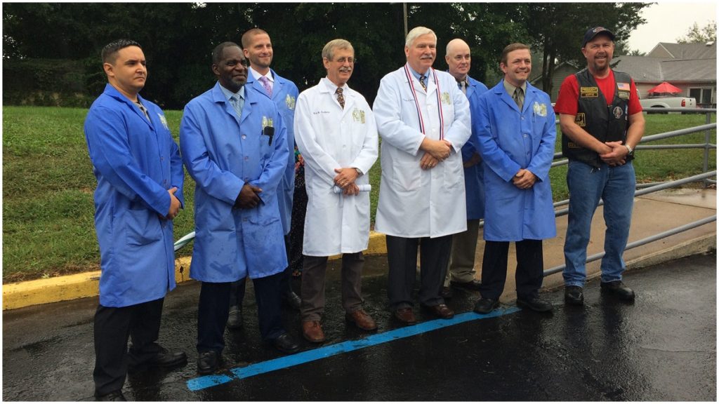 vwi_169 Inaugural class of the Odessa Center for Horological Excellence (Students in blue lab coats; Rick Aubin, instructor, and Sam Cannan, founder, both in white; Michael Wipf, president of Hogs and Heroes' Middletown chapter) (Shirley Min/WHYY)