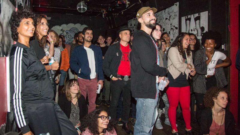 Attendees of the first annual YallaPunk Festival listen and laugh as comedy headliner Aron Kader closes out the day at The Barbary. (Emily Cohen for WHYY)