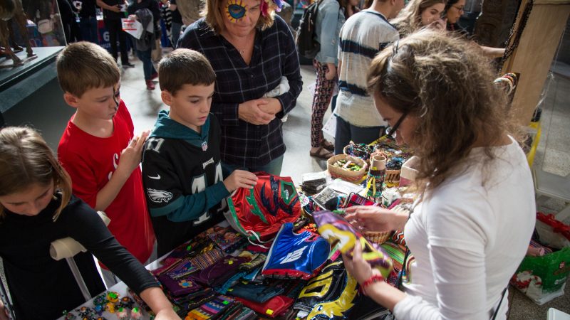Children sort through lucha libre masks, used by Mexican professional wrestlers, for sale at a day of the dead celebration