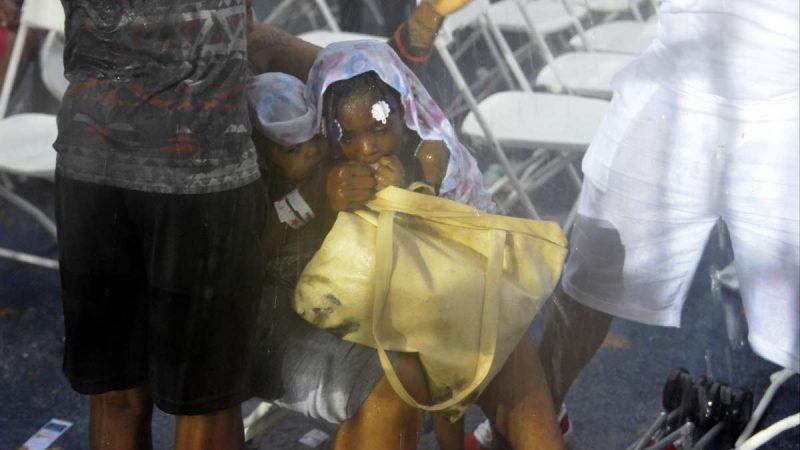 Audience members wait out the rain during the Fourth of July concert on the Parkway.