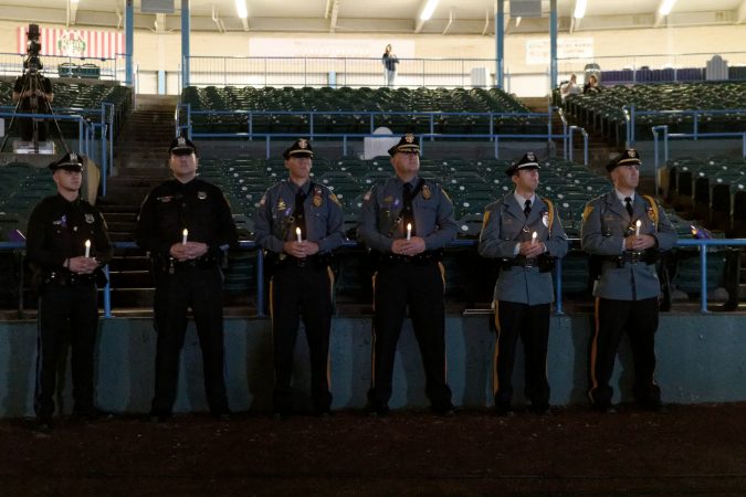 Police officers hold candles during the Regional Candlelight Vigil on October 14, 2017, at Camden Waterfront Stadium. (Bastiaan Slabbers for WHYY)