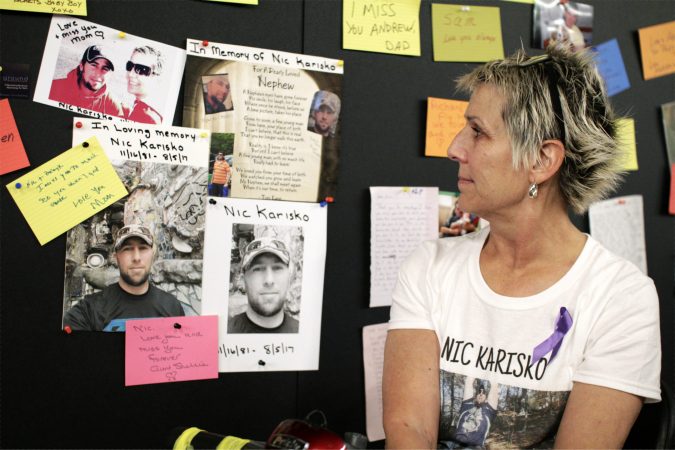 Luann Parkin looks at photos of her son, Nic Karisko, posted on the Memory Wall  at the Regional Candlelight Vigil at Camden Waterfront Stadium on October 14, 2017. (Bastiaan Slabbers for WHYY)