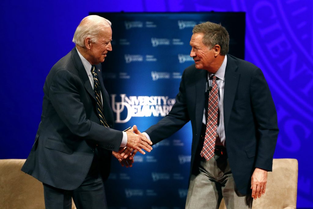 Former Vice President Joe Biden, left, and Ohio Gov. John Kasich shake hands after participating in a discussion on bridging political and partisan divides at the University of Delaware in Newark, Del., Tuesday, Oct. 17, 2017. (AP Photo/Patrick Semansky)