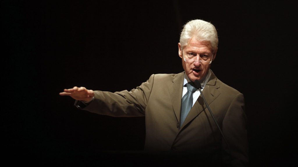 Bill Clinton Bill Clinton, olive suit, arm outstreched gesturing, black background
