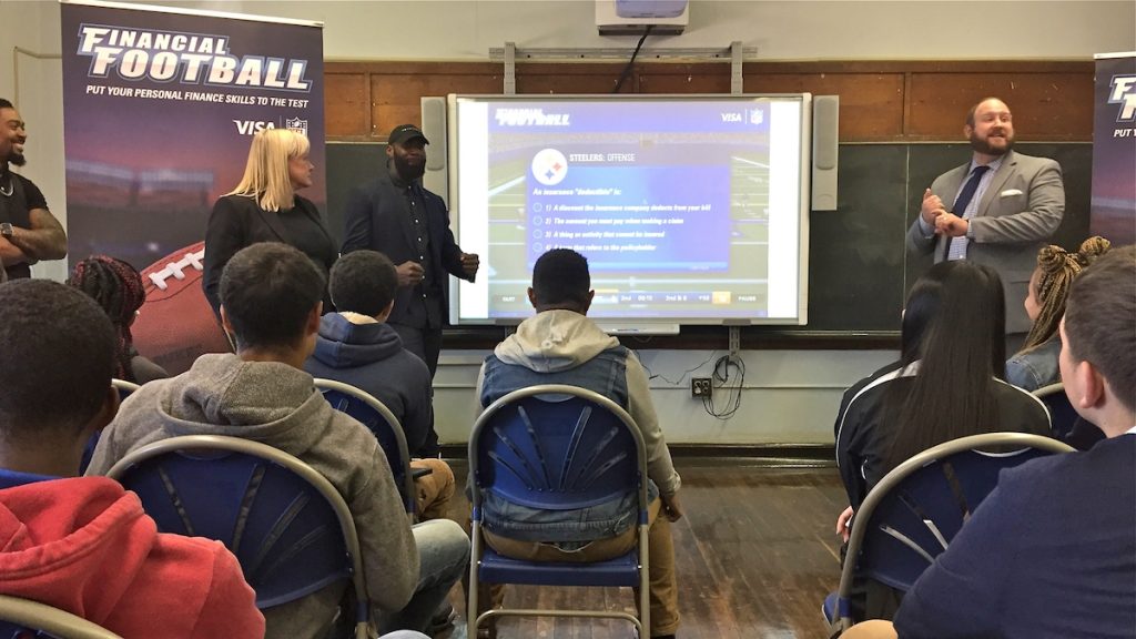 AVI Eagles player Malcolm Jenkins (center left) speaks about financial literacy to students at Bodine High School in Philadelphia (Avi Wolfman-Arent/WHYY)