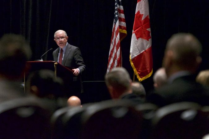 Sessions on stage, American and Canadian flag in the background