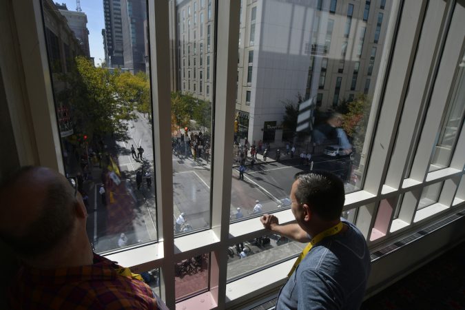 People look down through a window onto the protesters and officers below
