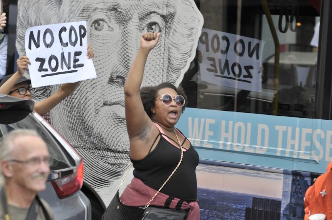 A woman holds her fist in the air, Washington's face, a window decal in the background