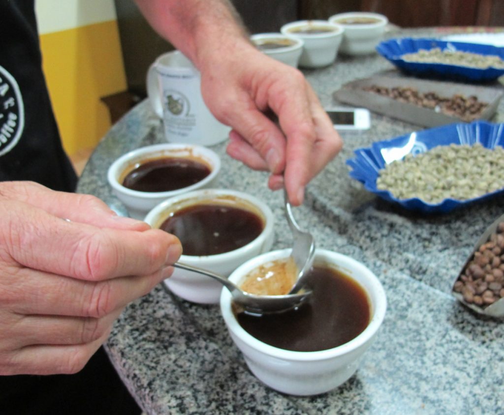 SIPASPcostaricacoffeex1200 A trio of small coffee cups, similar to espresso, a barrista works two spoons and froth