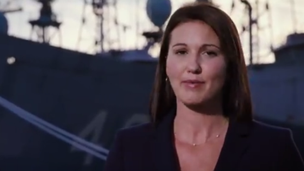 YOUTUBEreddickx1200 A woman speaks with a warship in the background