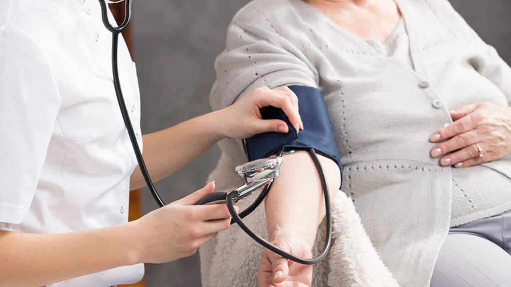 Nurse Taking Elderly Woman’s Blood Pressure Nurse taking elderly woman's blood pressure in nursing home