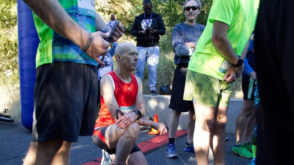 bs1343_-_2017_all_rights_reserved_bastiaan_slabbers_20171001_1705155709 Kevin Peter, of West Mt. Airy, takes a knee in protest during the National Anthem at the start of the WXPN 5K, on Sunday. (Bastiaan Slabbers for WHYY)