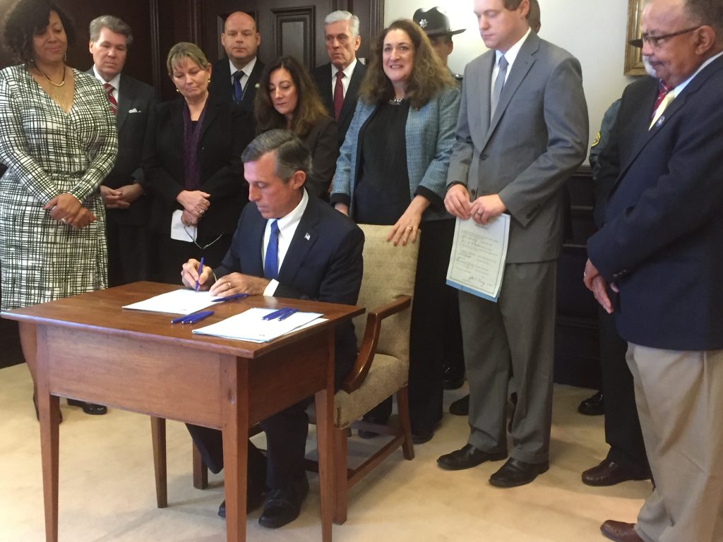 Delaware Gov. John Carney signs several bills to reform the state's juvenile justice system. (Zoë Read/WHYY)