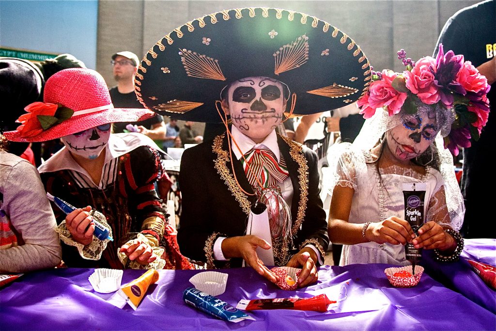 cohen-day_of_the_dead-15 Children in costume with skull face paint decorate sugar skulls.
