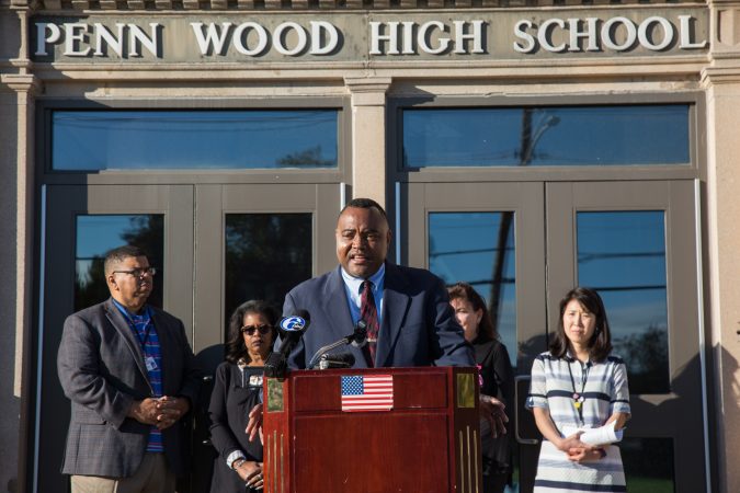 A man at a podium outside the Penn Wood High School