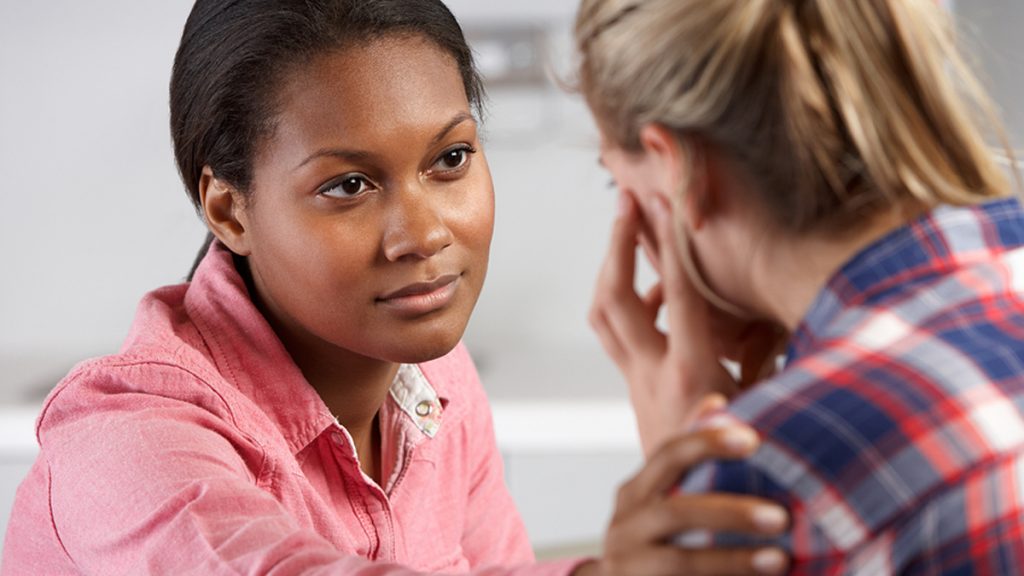 depression_1200x675 A woman reaches out to help another woman.