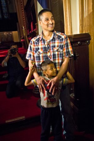 Javier Garcia Flores and his son Javier, 5, wait inside the sanctuary of the First United Methodist Church on Arch Street in Philadelphia, before Flores will take his first steps outside the church since November of 2016. (Kimberly Paynter/WHYY)