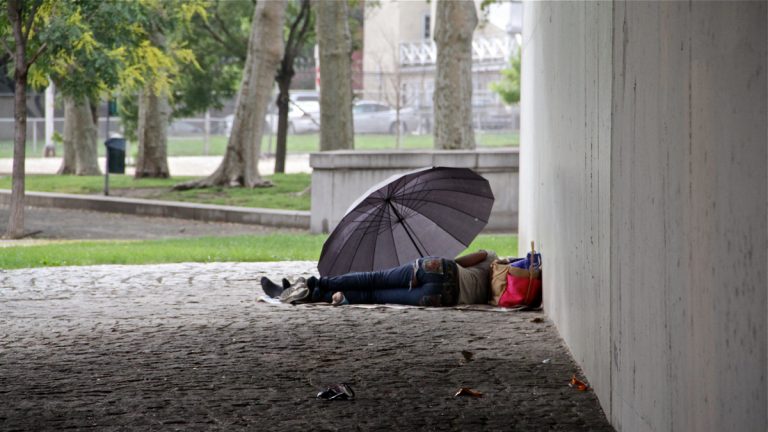 Homeless A homeless person is shown sleeping under an umbrella.