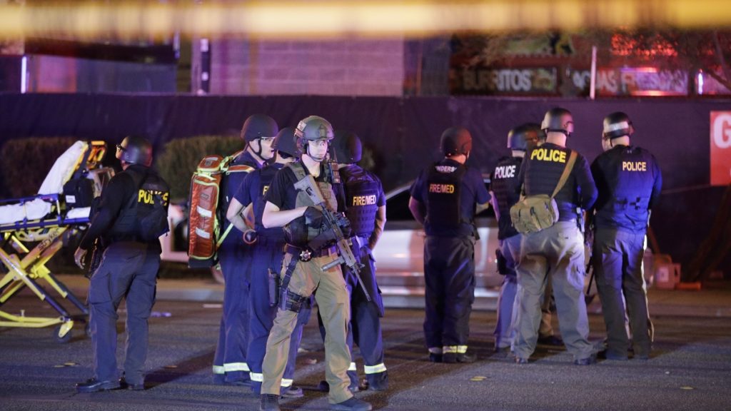 l_ap_17275269771745 Police officers and medical personnel stand at the scene of a shooting near the Mandalay Bay resort and casino on the Las Vegas Strip