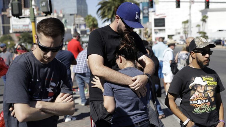 Reed Broschart, (center), hugs his girlfriend Aria James on the Las Vegas Strip in the aftermath of a mass shooting at a concert Monday, Oct. 2, 2017, in Las Vegas.