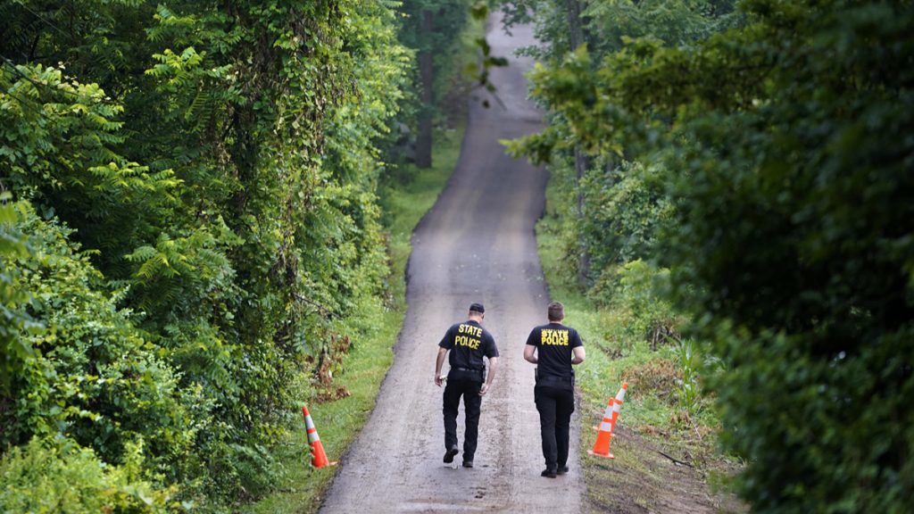 Missing Men Pennsylvania State Police officers walk up a driveway, Friday, July 14, 2017, in Solebury, Pa. (AP Photo/Matt Rourke)