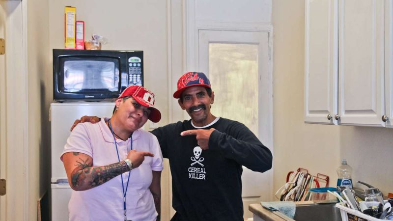 Nancy Falcon, certified peer specialist with Pathways to Housing, helped Israel Reyes into an apartment after those living on the Conrail Train tracks were forced to move in early August. (Kimberly Paynter/WHYY)