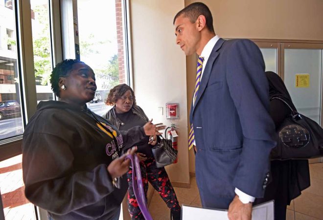 After the October 2016 NJ Schools Development Authority meeting in Trenton where the plan to demolish Camden High was approved, activists Moneke Singleton-Ragsdale, left; and Vida Neil confront Camden School Superintendent Paymon Rouhanifard. (April Saul/for Newsworks)