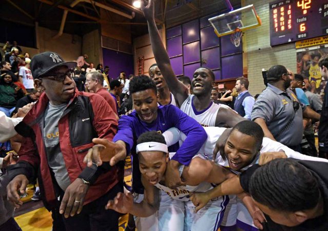 Camden High basketball players exult after a playoff victory against Haddonfield Memorial High School in March 2017; the game was billed as the last ever to be played in the Clarence Turner gymnasium before the school would be demolished. (April Saul/for Newsworks)