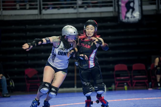 The Gotham Girls Roller Derby team, in black, vie against the Denver Roller Derby Team during the WFTDA International Championship at the Liacouras Center. (Brad Larrison for WHYY)