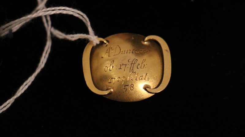 The reverse of the mourning slide identifies the deceased, A. Duncumb, who died on Feb. 17, 1709 at the age of 58.