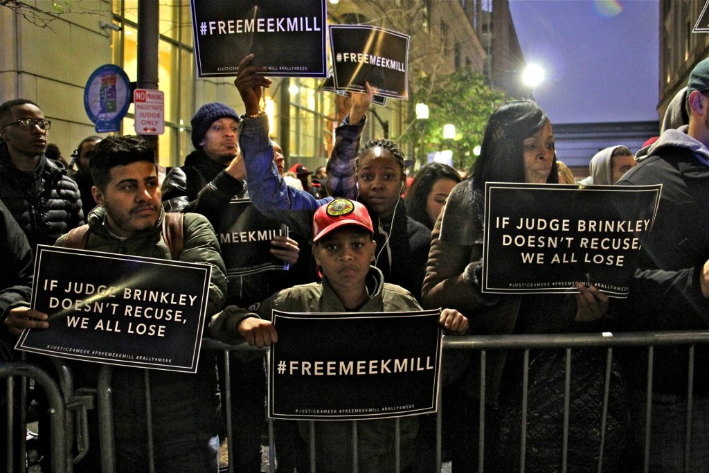 2017 11 13-e lee-philadelphia center for criminal justice-rally for meek mill People holding Free Meek Mill signs crowd up to a barrier outside the center for criminal justice