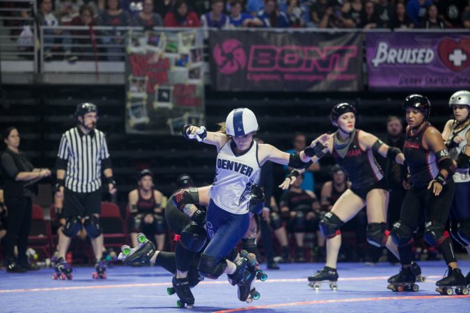 The Gotham Girls Roller Derby team, in black, vie against the Denver Roller Derby Team during the WFTDA International Championship at the Liacouras Center. (Brad Larrison for WHYY)