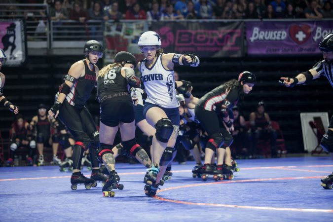The Gotham Girls Roller Derby team, in black, vie against the Denver Roller Derby Team during the WFTDA International Championship at the Liacouras Center. (Brad Larrison for WHYY)