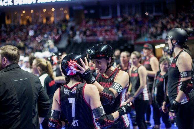 Members of the Gotham Girls Roller Derby Team celebrate winning third place at the WFTDA international Championship at The Liacouras Center Sunday. (Brad Larrison for WHYY)