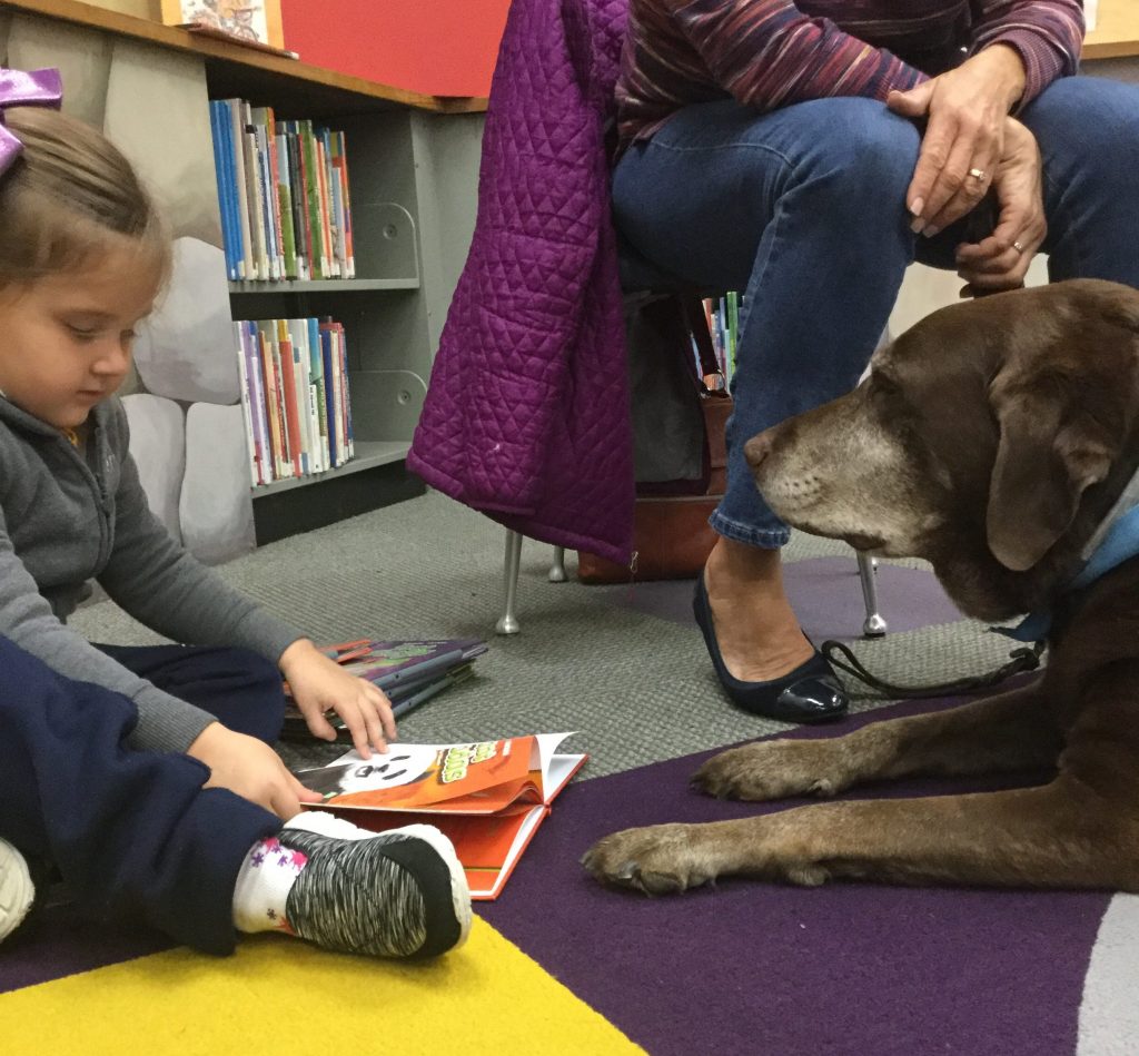 5D5B2566-AE49-496A-BE28-B8C718EC9764 Mia Zelmanoff reads a book to Rocky at the Torresdale library in Northeast Philly.