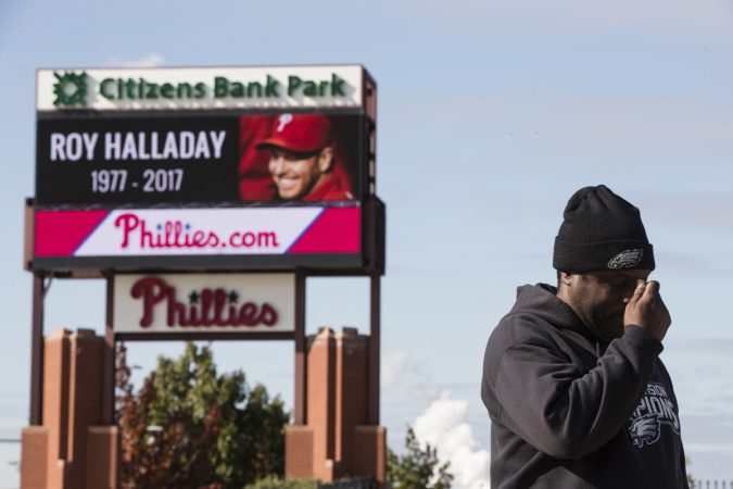Michael Aikens crosses himself as he pays his respects outside Citizens Bank Park at a makeshift memorial for former Phillies pitcher Roy Halladay in Philadelphia, Wednesday, Nov. 8, 2017. (Matt Rourke/AP Photo)