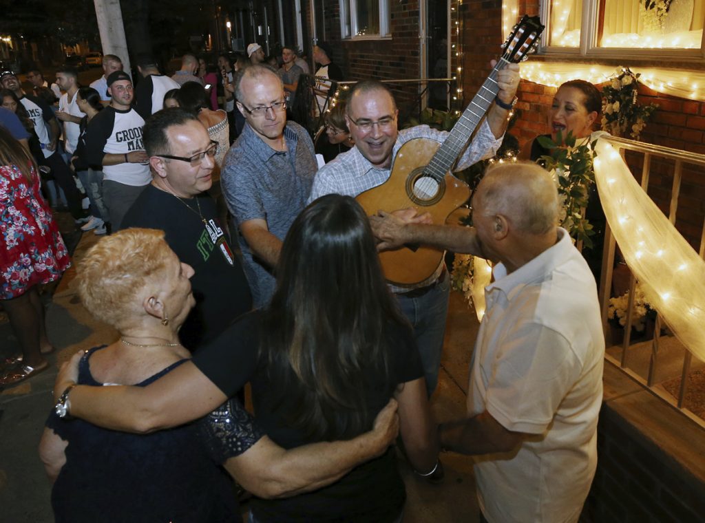 Vincenzo Longo Cousin of the bride, Vincenzo Longo, plays the guitar as a crowd gathers in the street outside the decorated home of Susan and Larry Longo during the Italian wedding serenade for their daughter Stephanie Longo, Saturday, Oct. 7, 2017, in Philadelphia, Pa. An Italian wedding tradition is alive and well in south Philadelphia, where young couples are transforming something old into something new with their take on the wedding serenade. (Mel Evans/AP Photo)