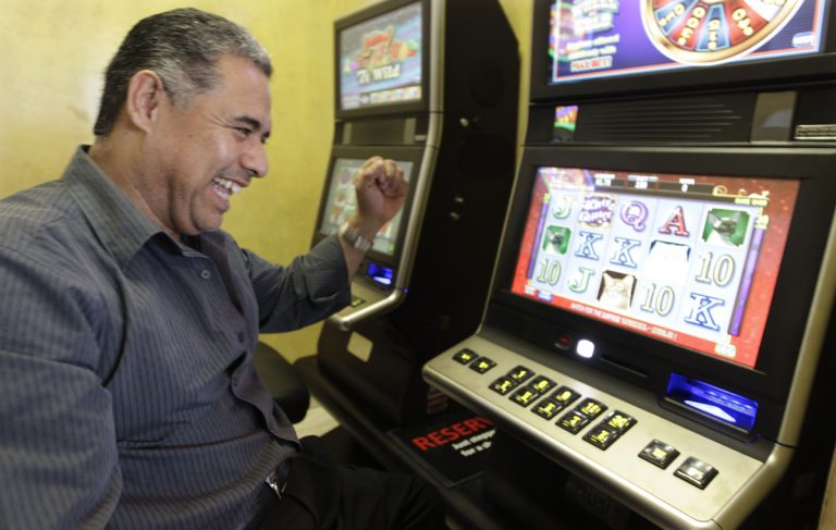 Chino Roberto Vasquez, owner of Chino's Pizzeria celebrates a winning hand on one of the new legal video poker machines, in his restaurant Tuesday, Oct. 9, 2012, in Justice, Ill. (M. Spencer Green/AP Photo)