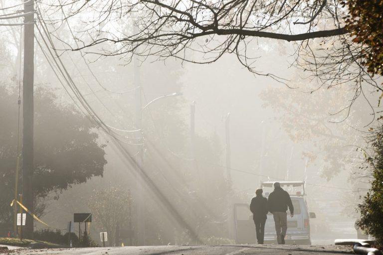 With smoke heavy in the air, a couple walks in the vicinity of a fire at the the Barclay Friends Senior Living Community in West Chester, Pa., Nov. 17. 2017. (Matt Rourke/AP Photo)