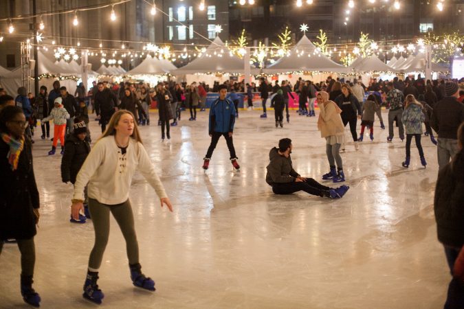 Ice skaters glide around the rink installed at Dilworth Park Friday evening during the Christmas tree lighting ceremony and opening of the Christmas Village. (Brad Larrison for WHYY)